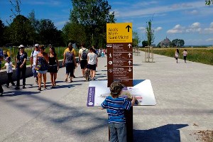 UNE VISITE TYPIQUE DU MONT SAINT MICHEL DEPUIS LES NOUVEAUX AMÉNAGEMENTS D'ACCÈS ET DE STATIONNEMENT. ARRIVÉE DANS LES NOUVEAUX PARKING, LE CENTRE D'INFORMATION, LA PLACE DES NAVETTES, LA VISITE DU BARRAGE, LES NAVETTES, L'ARRIVÉE AU MONT, SES COMMERCES, VISITES DE L'ABBAYE ET DU SPECTACLE NOCTURNE.LE MONT SAINT MICHEL, MANCHE, NORMANDIE, FRANCE. JUILLET-AOUT 2012.